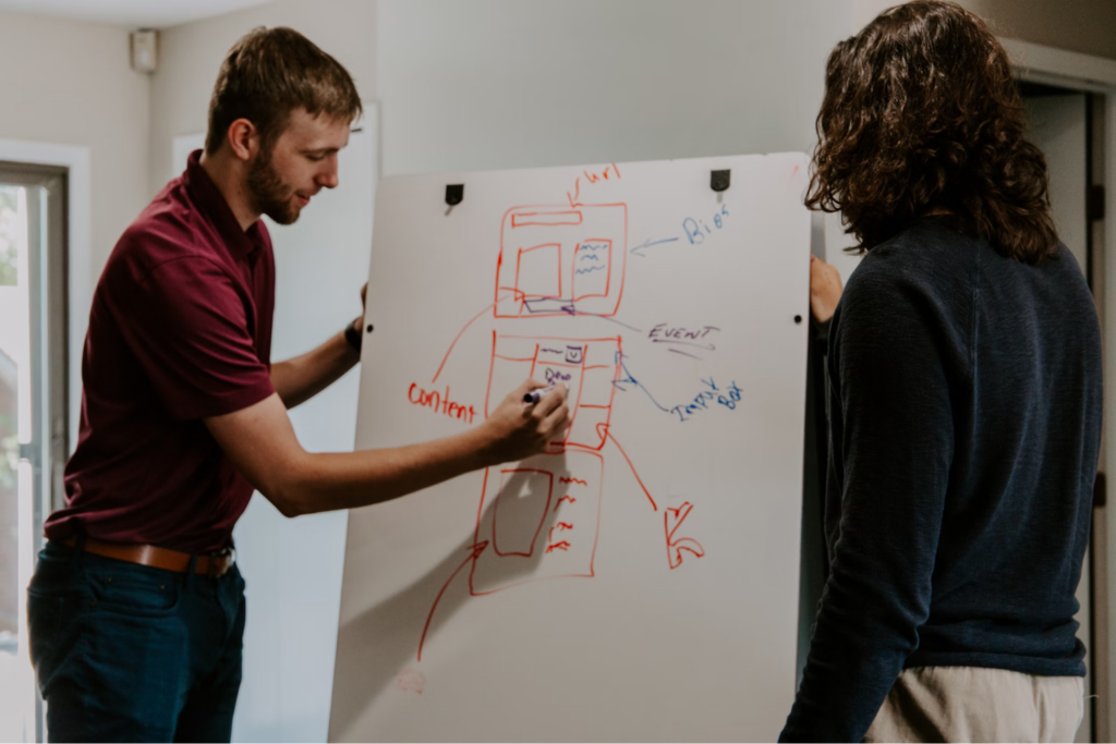 Man drawing on dry-erase board showcasing crafting content